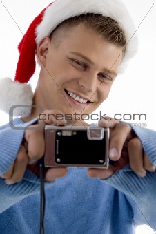 young man with christmas hat and camera