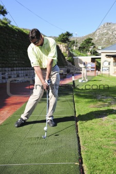 Handsome young golfer in action