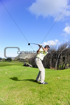 Handsome young golfer in action