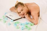 Blonde woman in spa dreaming on weight scales
