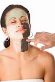 Spa treatment - color facial mask on ethnic woman
