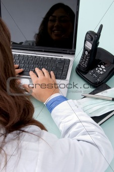half length view of doctor working on laptop
