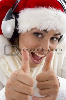 woman wearing christmas hat and showing thumbs up