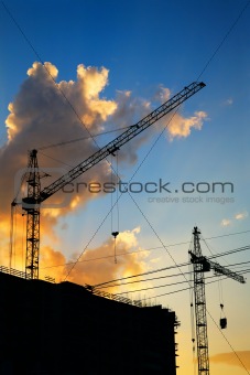 hoisting crane silhouette on sunset sky