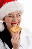 woman wearing christmas hat and eating biscuit