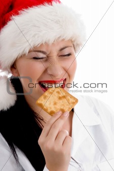 woman wearing christmas hat and eating biscuit