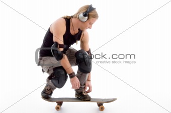 handsome guy tying his shoes laces and sitting on skateboard