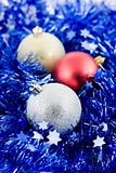 christmas colored balls in blue tinsel vertical orientation soft
