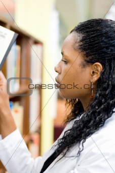student in library searching for books