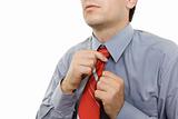 Man adjusting red tie