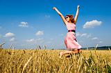 Happy woman jumping in golden field