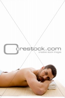 side view of man lying down on mat at spa 