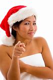 portrait of young woman with christmas hat pointing towards