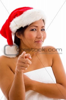 portrait of young woman with christmas hat pointing towards