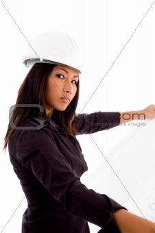 young constructor holding blue prints and looking at camera