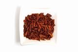bird eye chili pepper in square white bowl isolated