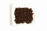 whole cloves in square white bowl isolated