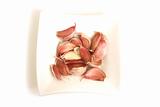 garlic cloves in square white bowl isolated