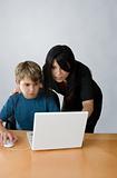 Adult assisting child on computer