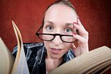 Peprlexed woman with big eyes reading a book