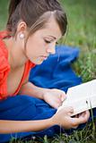 young girl relaxing and reading a book