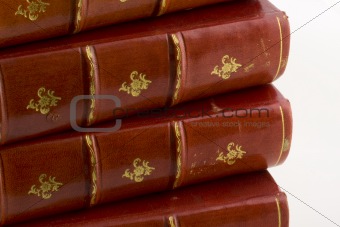 stack of old books in red leather with gold engravings