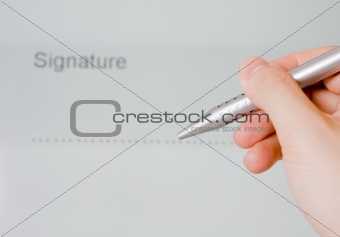 Hand holding pen with document