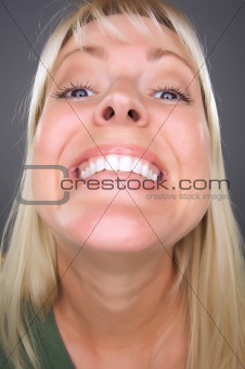 Beautiful Blond Woman with Big Smile against a Grey Background