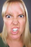 Angry Blond Woman Against a Grey Background.