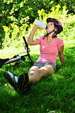 Teenage girl resting in a park with a bicycle