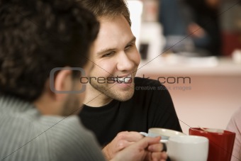 Young Man Toasting with Coffee Cups