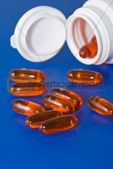 Orange pills on blue surface