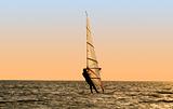 Silhouette of a windsurfer on waves of a gulf 
