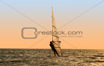 Silhouette of a windsurfer on waves of a gulf 