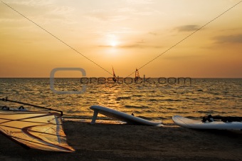 Silhouette of a two windsurfer on a gulf on a sunset