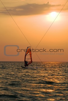 Silhouette of a windsurfer on a gulf on a sunset