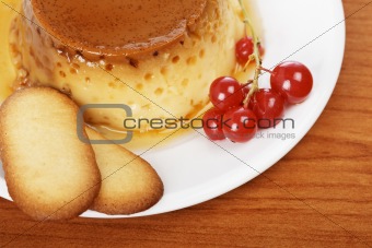 Cream caramel dessert with red currants and cookies
