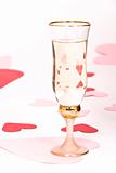 glass of white wine on white heart covered background