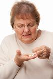 Attractive Senior Woman and Pills Isolated on a White Background.