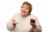 Confused Senior Woman Holding Apple and Vitamins Isolated on a White Background.