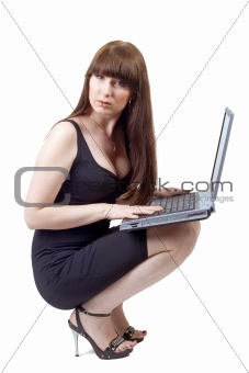 The young businesswoman sits with the laptop in a lap