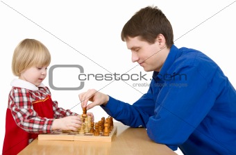 Man and child play chess