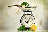 Weight scale with fish and lemons against a grungy, antique back