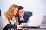 young couple surfing the internet on a laptop