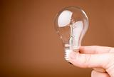 Hand holding light bulb on the beige background