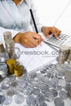 Woman working on accounting with many coins around