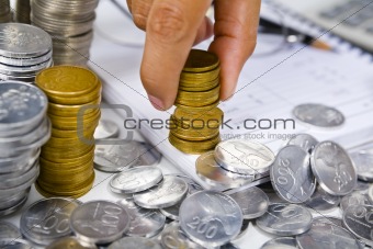 Hand put coins in stack on the book