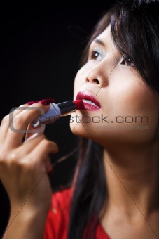 Young woman using lipstick