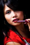 Young woman using lipstick brush