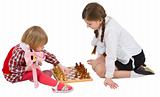 Girl teaching little girl play chess